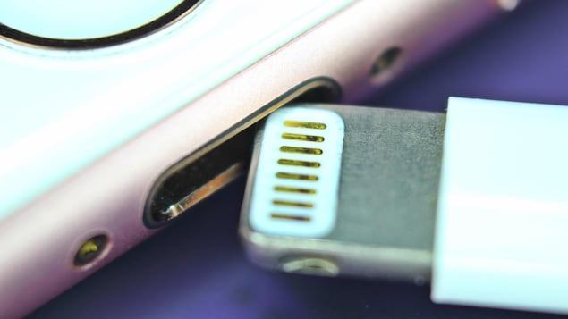 Un gros plan sur le port Lightning d'un iPhone. Un câble Lightning est en train d'être inséré dans le téléphone. Un gros plan sur le port Lightning d'un iPhone. Un câble Lightning est en train d'être inséré dans le téléphone.