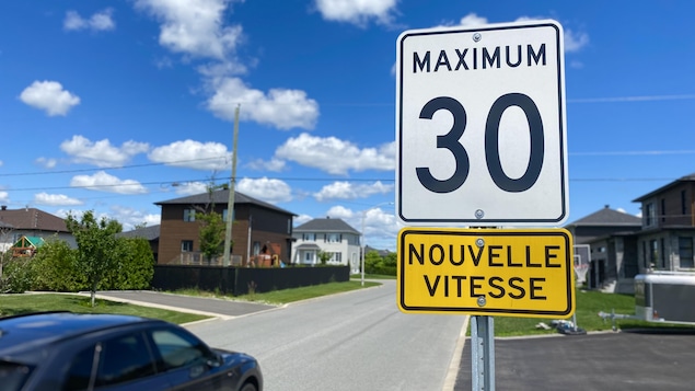 Une pancarte qui indique une "nouvelle vitesse" de 30 km/h dans un quartier résidentiel.