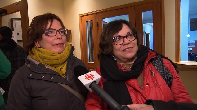 Plan moyen des deux femmes s'exprimant dans un micro de Radio-Canada. Plan moyen des deux femmes s'exprimant dans un micro de Radio-Canada.