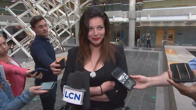 Lisa Mahmoud, vêtue de noir, répond aux questions des journalistes au Palais justice.