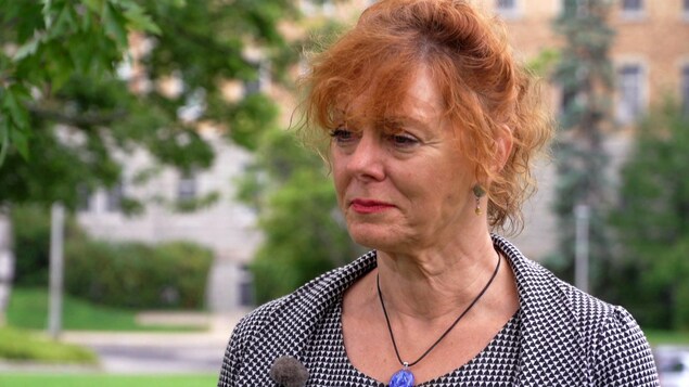 Une dame aux cheveux frisés ne entrevue à l'extérieur.
