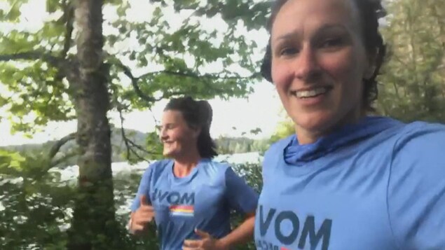 Lise Bérubé regarde son cellulaire pendant qu'elle court un marathon aux côtés d'une deuxième femme.