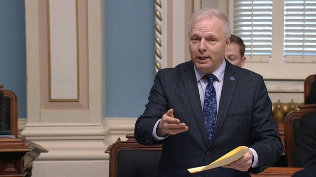 Le chef du Parti québécois, Jean-François Lisée, tient des feuilles jaunes dans ses mains lors de la période de questions à Québec. Il discute de la motion déposée par son parti, jeudi à l'Assemblée nationale, sur l'abandon de la formule d'accueil « bonjour, "hi" » dans les commerces québécois.
