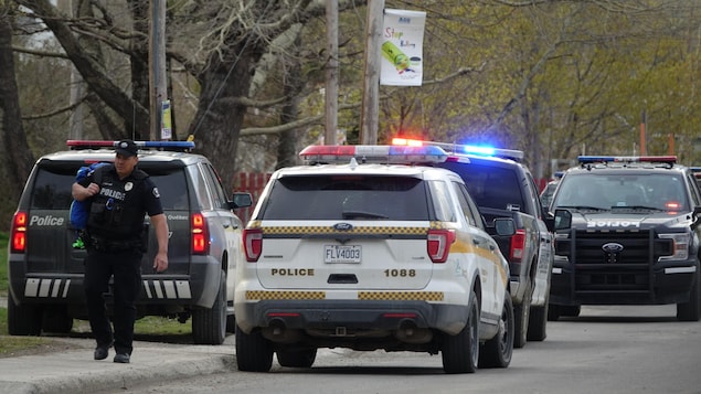 Des voitures de police et un agent de la Sûreté du Québec.