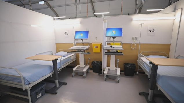 Une chambre d'hôpital avec deux lits et des machines.