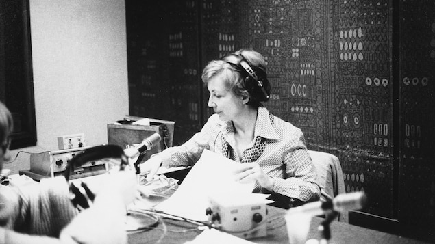 Lizette Gervais maniant ses feuilles et son micro dans un studio radio.