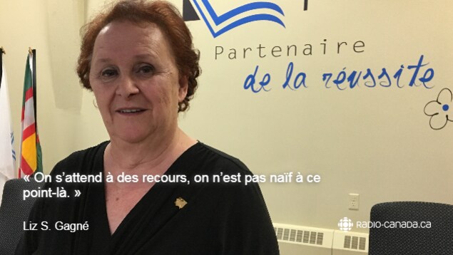 Une femme âgé habillé en noir sourit à la caméra. Une femme âgé habillé en noir sourit à la caméra.