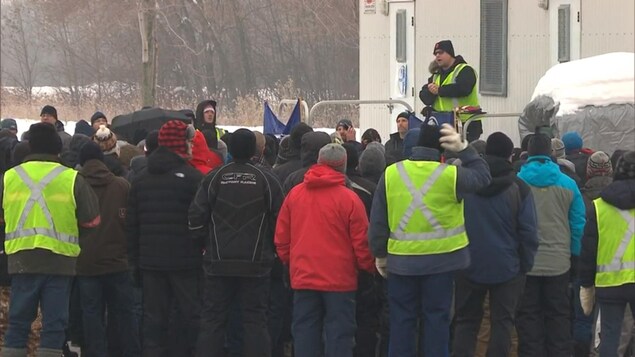 Des travailleurs en lock-out de l'Aluminerie de Bécancour se rassemblent devant la roulotte syndicale le 11 janvier 2018.