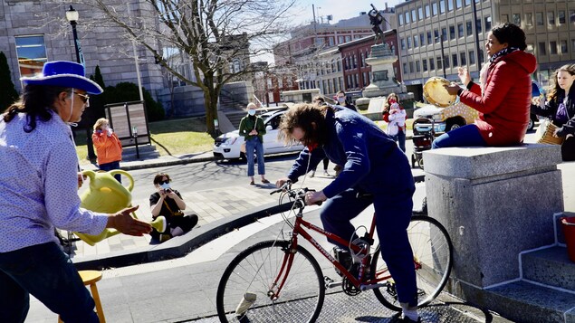 Des comédiens qui font une pièce de théâtre, dont un homme sur un vélo.