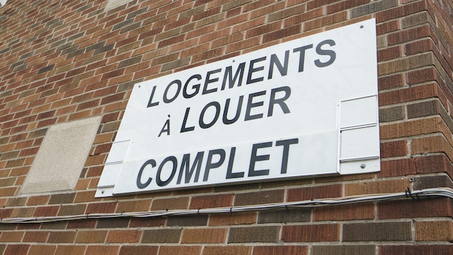 Une pancarte qui dit «Logements à louer. Complet.» sur un immeuble.