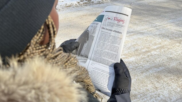 Une personne tient un journal dans ses mains