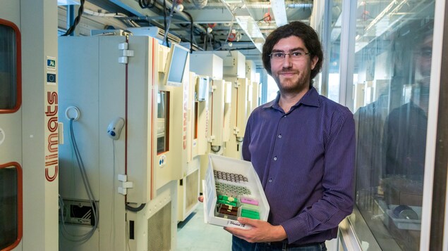 Loïc Boulon dans le laboratoire contenant des climatiseurs, tient une boîte de batteries dans les mains. Loïc Boulon dans le laboratoire contenant des climatiseurs, tient une boîte de batteries dans les mains.