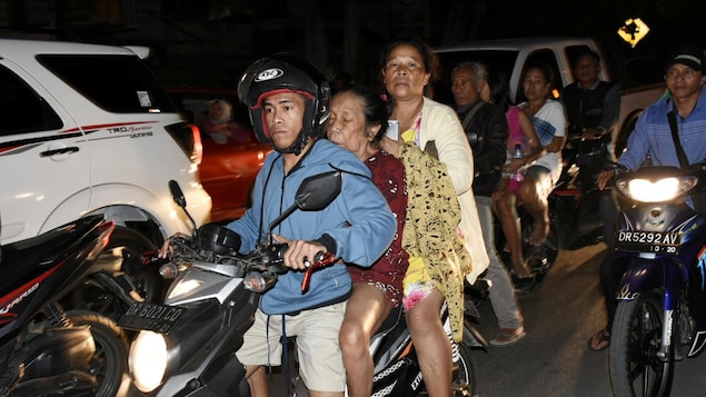Scène de congestion routière alors que des résidents de Lombok cherchent à évacuer les zones près des côtes dans des voitures et sur des mobylettes. 