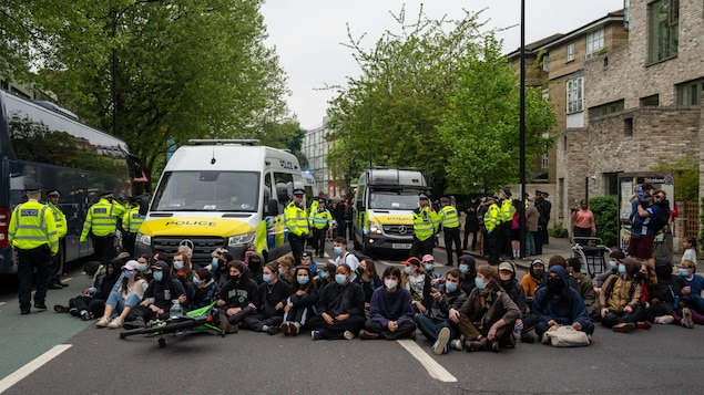 Des manifestants bloquent une route devant un bus qui devait transporter des migrants depuis un hôtel, le 2 mai 2024 à Peckham, Londres.
