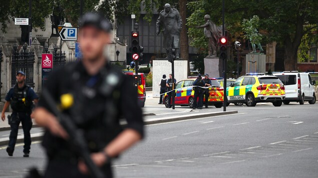 Un policier armé se tient à l'extérieur du palais de Westminster. Un policier armé se tient à l'extérieur du palais de Westminster.