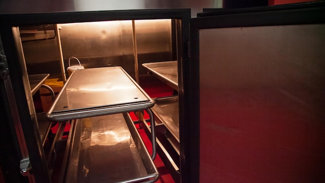 Un plateau en métal à deux niveaux se trouve dans un réfrigérateur de la morgue.