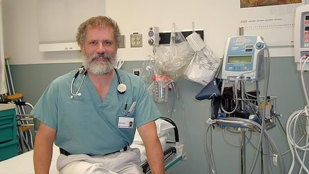 Louis Hugo Francescutti assis sur un lit dans une salle d’urgence.