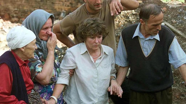 Louise Arbour visite un village au Kosovo où 13 personnes ont été tuées par les forces armées Serbes, en juillet 1999.