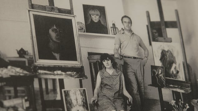 Louise Carrier pose avec plusieurs œuvres.