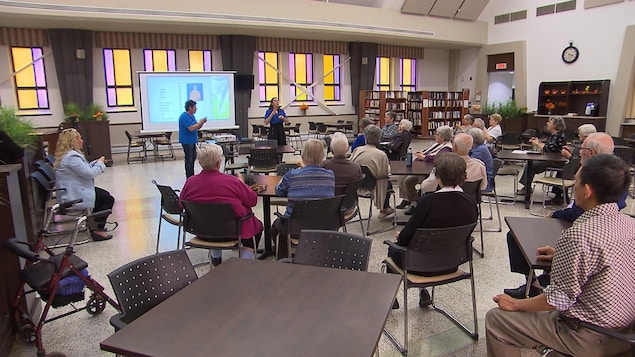Plusieurs aînés suivent une formation dans une salle commune dans la résidence Saint-Eugène.