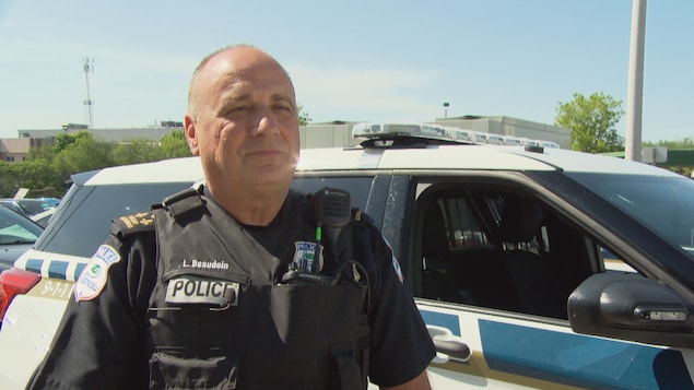 Un policier arrêté près d'un véhicule de patrouille.