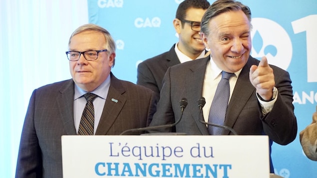 Luc Provençal et François Legault lors d’un point de presse. Sur la photo, on aperçoit le chef de la CAQ faire un clin d’œil en pointant le doigt vers une personne de l’assistance. Luc Provençal et François Legault lors d’un point de presse. Sur la photo, on aperçoit le chef de la CAQ faire un clin d’œil en pointant le doigt vers une personne de l’assistance.