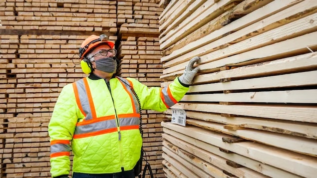Darcy Elliott, shipping supervisor at Spray Lake Sawmills, inspects lumber at the company's facility in Cochrane, Alta. in May.
