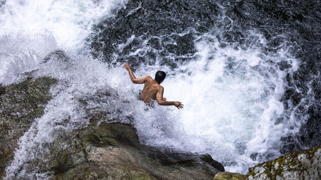 Un adolescent saute dans les eaux d'une falaise dans le secteur de Lynn Valley Canyon, à North Vancouver.