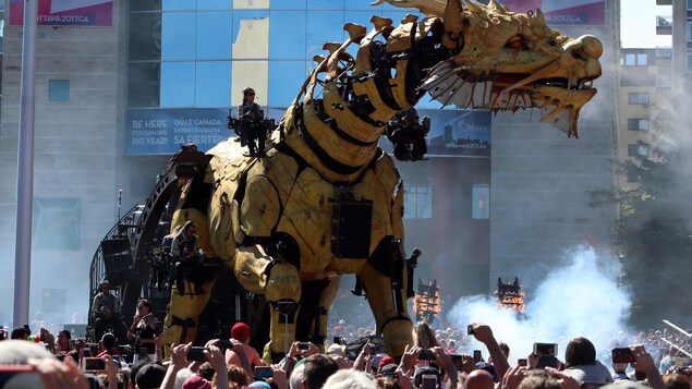 Le dragon géant derrière des milliers de personnes qui photographient La Machine. Le dragon géant derrière des milliers de personnes qui photographient La Machine.