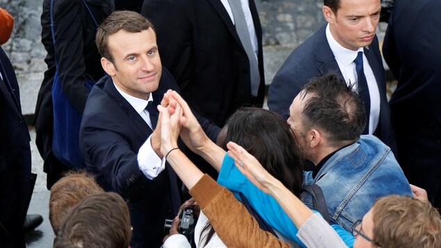 Le président français sert la main de passants à l'Arc de Triomphe.