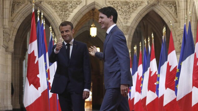Une haie de drapeaux de la France et du Canada déployée dans le hall d'honneur du parlement à Ottawa.