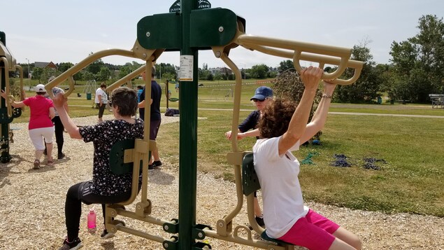 Des aînés utilisent les stations d'exercice mises à leur disposition au parc Beauséjour à Rimouski.