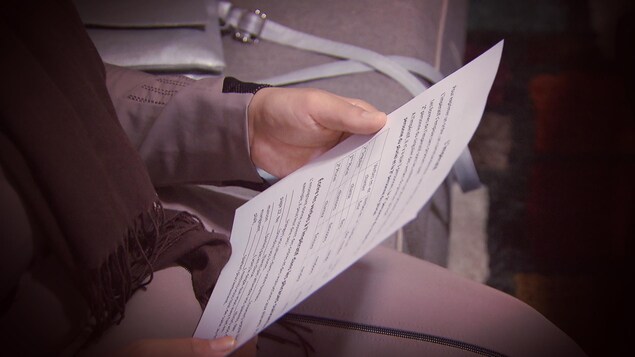 Une des participantes tient une feuille d'exercices en main. Une des participantes tient une feuille d'exercices en main.