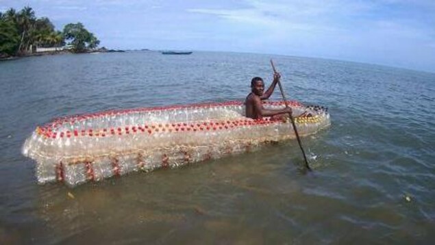 Au Cameroun, à Douala, un jeune homme vogue sur l'un des bateaux qu'il a conçus à partir de bouteilles en plastique recyclé. Au Cameroun, à Douala, un jeune homme vogue sur l'un des bateaux qu'il a conçus à partir de bouteilles en plastique recyclé.