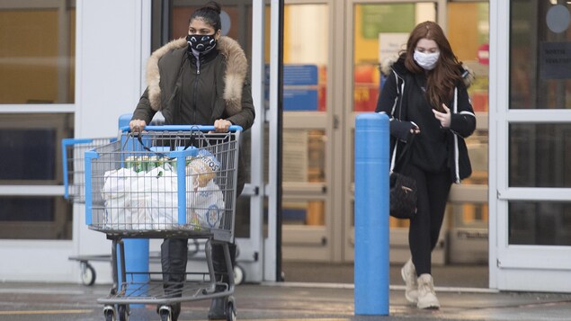 Deux femmes sortent d'un magasin à grande surface.