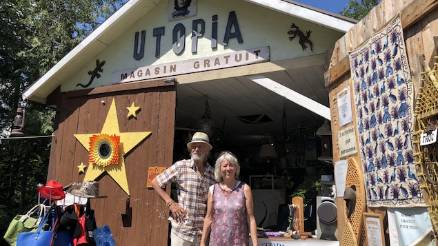 Un couple se tient devant un cabanon transformé en magasin où les objets sont gratuits.