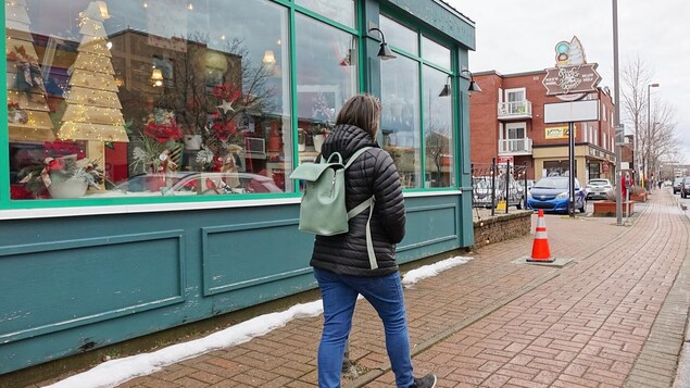 Une personne marche devant des commerces de la rue Saint-Germain, à Rimouski.