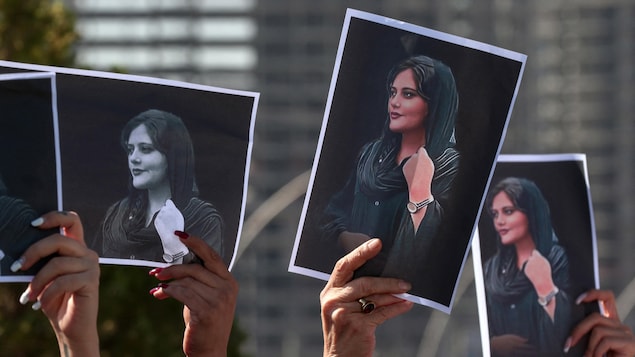 Des femmes brandissent des photos de Mahsa Amini lors d'une manifestation en Iran le 22 septembre 2022. 