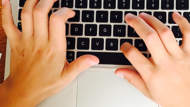 Des mains d'enfant sur un clavier d'ordinateur Des mains d'enfant sur un clavier d'ordinateur