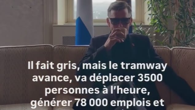 Bruno Marchand bois un café avec des lunettes soleil.