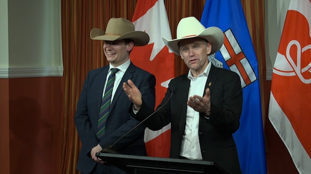 Deux hommes s'adressent aux médias en portant des chapeaux de cowboy.