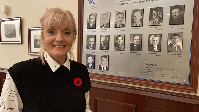 On aperçoit la mairesse de la ville, Sylvie Beaumont, souriante, devant l'encadré mural présentant les anciens maires de la ville.