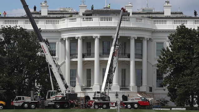 Grues et travailleurs de la construction au travail devant la façade de la Maison-Blanche. Grues et travailleurs de la construction au travail devant la façade de la Maison-Blanche.
