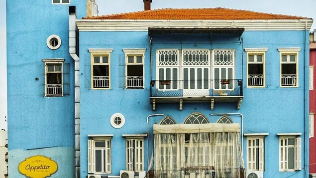 Une maison bleue sur fond de ciel gris