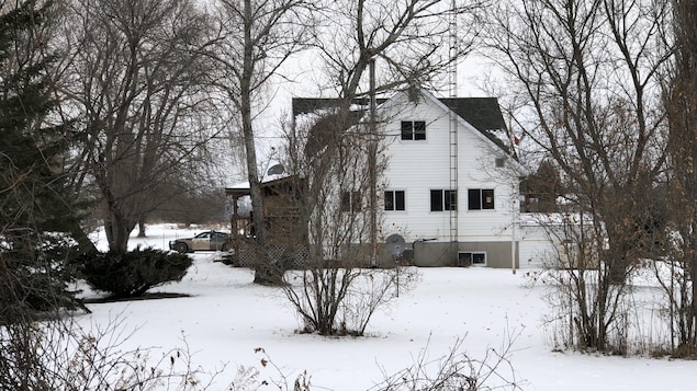 une maison blanche en hiver. une voiture de police est stationnée à l'avant. une maison blanche en hiver. une voiture de police est stationnée à l'avant.