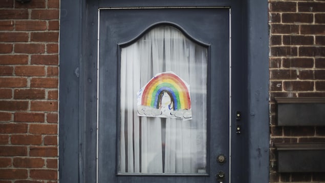 Un arc-en-ciel fait par un enfant collé sur une porte.