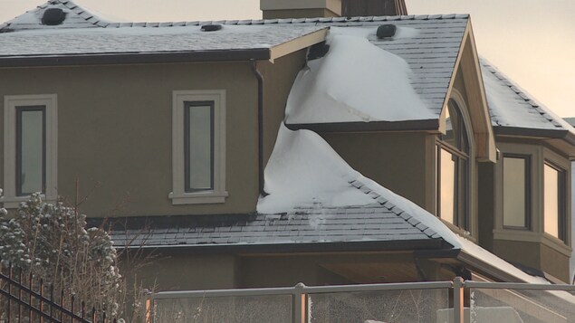 Une maison moderne avec quatre fenêtre et de la neige sur le toit en Alberta.