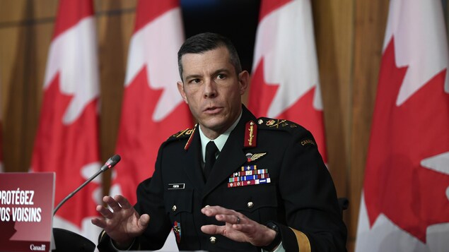 الميجور جنرال داني فورتان متحدثاً في مؤتمر صحفي وتبدو خلفه أعلام كندية.