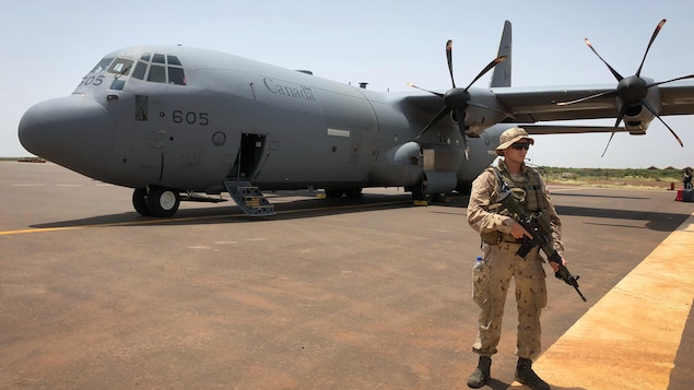 Un soldat monte la garde devant un Hercules CC-130. Un soldat monte la garde devant un Hercules CC-130.