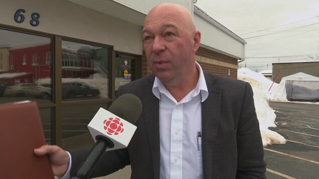 Régis Maltais en entrevue devant un édifice municipal Régis Maltais en entrevue devant un édifice municipal